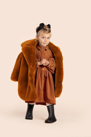 Rust kids faux fur coat, angle view, perfect for stylish warmth in winter. Ideal for little ones' outdoor adventures.