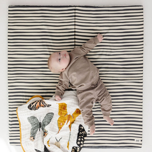 Bold stripe organic cotton play mat angled view, perfect for baby playtime and comfort.