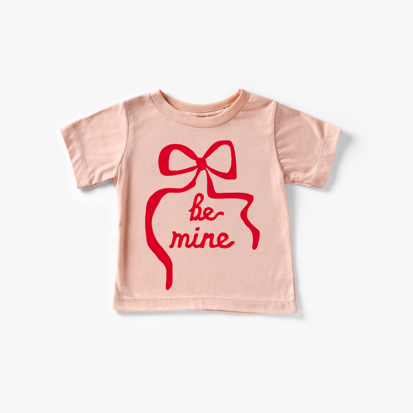 "Be Mine Ribbon baby top in angle view, featuring a cute design perfect for infants."