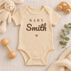 Styled flat lay of the Baby Surname baby bodysuit