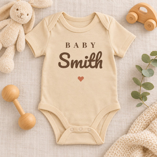 Styled flat lay of the Baby Surname baby bodysuit