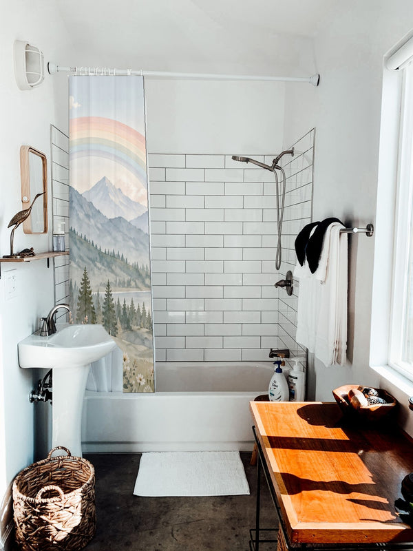 Alpine Lake Rainbow shower curtain hanging on the rod over a white bathtub