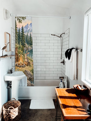 Woodland Adventure Camping shower curtain hanging on the rod over a white bathtub