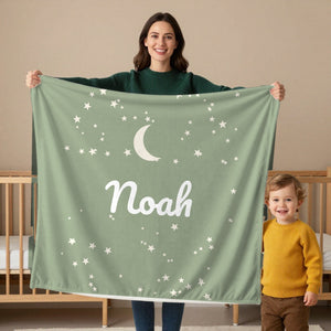 Moon and Stars toddler sherpa blanket in sage, held by a mom