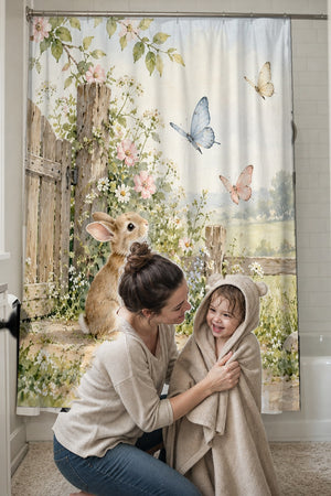 Mom drying her toddler in a hooded towel in front of the Butterfly Gate Bunny shower curtain