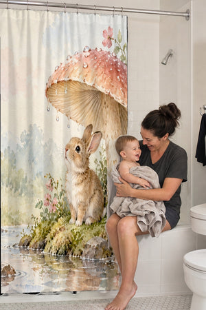 Mom holding her baby on the tub edge next to the After the Rain Bunny shower curtain