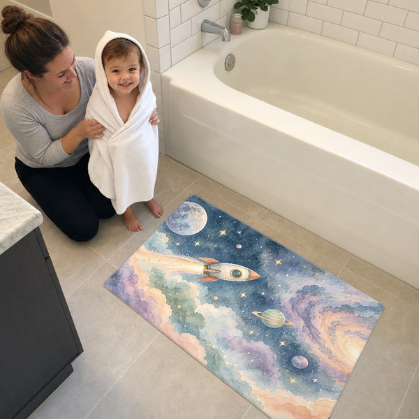 Mom and toddler in a hooded towel next to the Rocket Journey bath mat