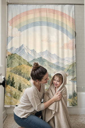 Mom drying her toddler in a hooded towel in front of the Golden Valley Rainbow shower curtain