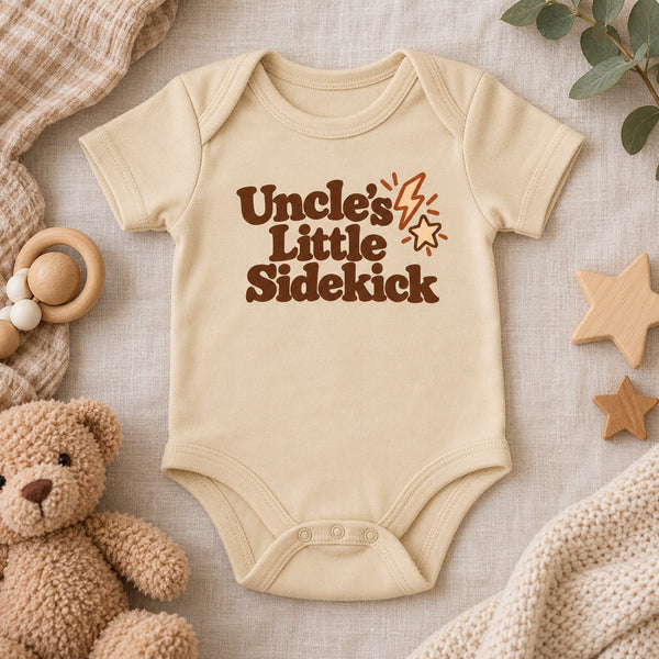 Styled flat lay of the Uncle's Little Sidekick baby bodysuit