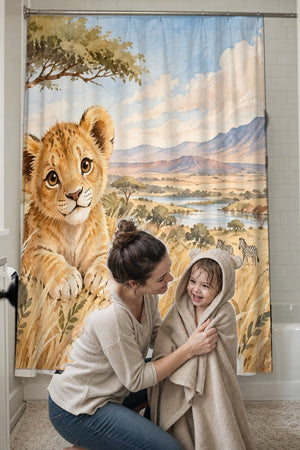 Mom drying her toddler in a hooded towel in front of the Lion Cub Safari shower curtain