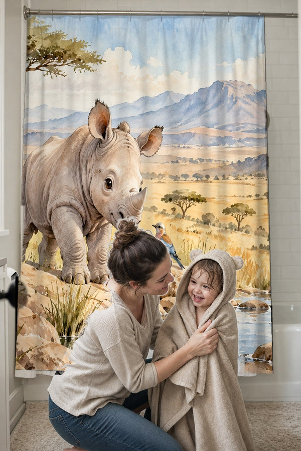 Mom drying her toddler in a hooded towel in front of the Baby Rhino Safari shower curtain