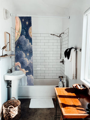 Moonlit Flight Hot Air Balloon shower curtain hanging on the rod over a white bathtub
