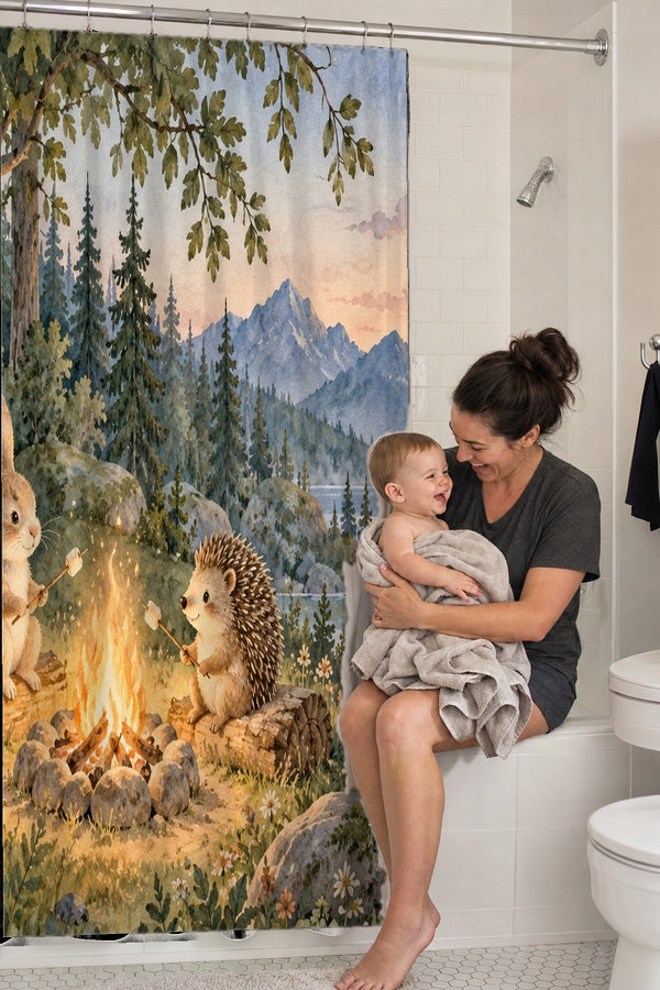 Mom holding her baby on the tub edge next to the Campfire Friends Camping shower curtain