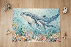 Top view of the Whale Family Ocean kids area rug on a wood floor