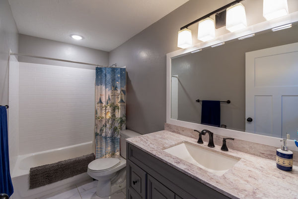 Moonlit Castle Fairy Tale shower curtain pulled open in a gray kids bathroom
