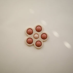 Colorful flower press toy for babies, designed to inspire creativity and sensory play.