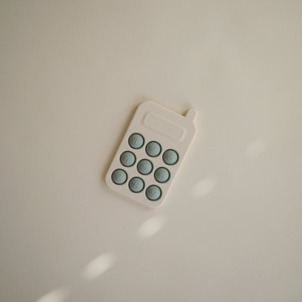 Colorful phone press toy for babies, designed to stimulate sensory play and fine motor skills.