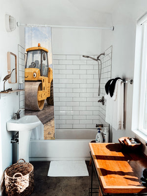 Road Roller shower curtain hanging on the rod over a white bathtub