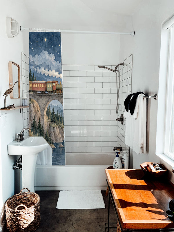 Moonlit Train shower curtain hanging on the rod over a white bathtub
