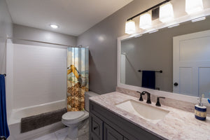 Construction Site shower curtain pulled open in a gray kids bathroom