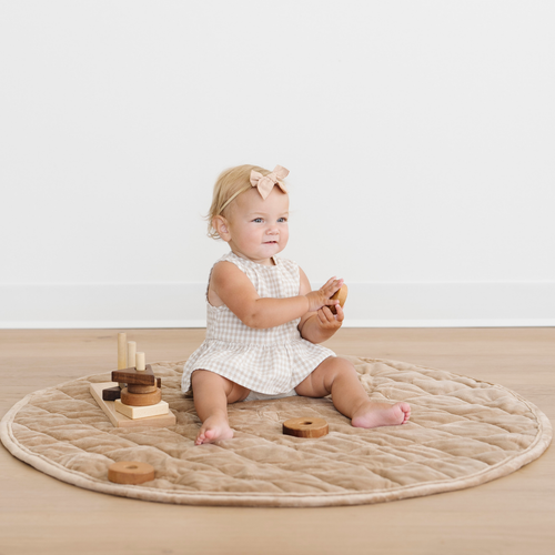 Minky play mat in soft colors, perfect for baby playtime, shown from an angled view.