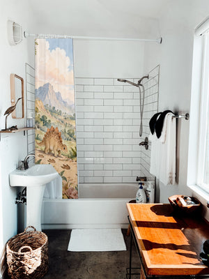 Footprint Valley Dinosaur shower curtain hanging on the rod over a white bathtub