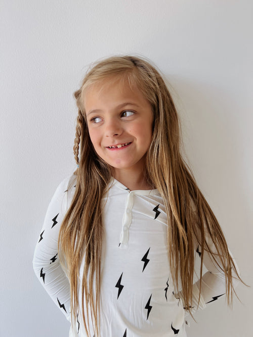 Bamboo two-piece pajamas for babies in white with black lightning bolt design, shown from angle 2.