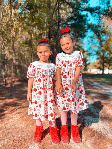 Smocked love bug dress for babies, featuring a charming design and comfortable fit. Perfect for any occasion.