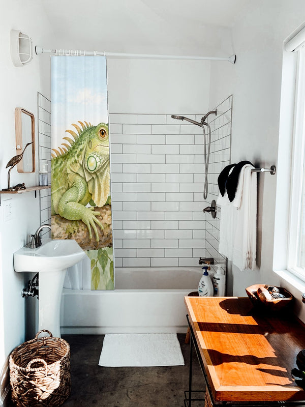 I is for Iguana Alphabet shower curtain hanging on the rod over a white bathtub