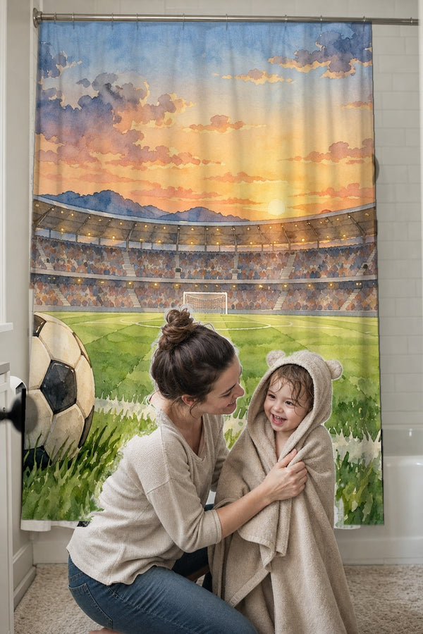Mom drying her toddler in a hooded towel in front of the Stadium Sunset Soccer shower curtain