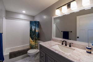Starry Tent Camping shower curtain pulled open in a gray kids bathroom