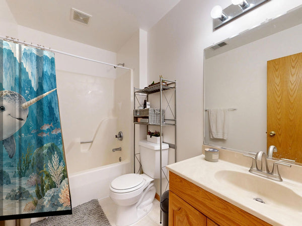Baby Narwhal Ocean shower curtain on a tub shower combo in an American family bathroom