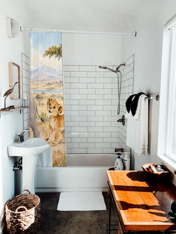 Safari Parade shower curtain hanging on the rod over a white bathtub