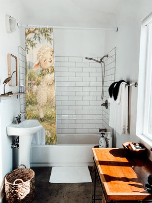 Lamb and Bunny Music shower curtain hanging on the rod over a white bathtub