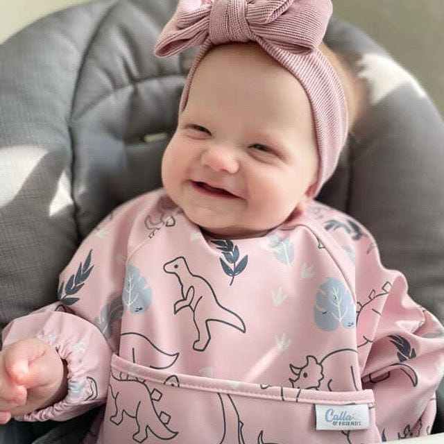 Grayson Long Sleeve Bib featuring a fun dinosaur design for mess-free mealtime. Perfect for babies and toddlers.