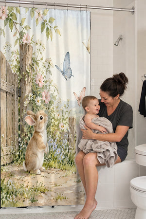 Mom holding her baby on the tub edge next to the Butterfly Gate Bunny shower curtain