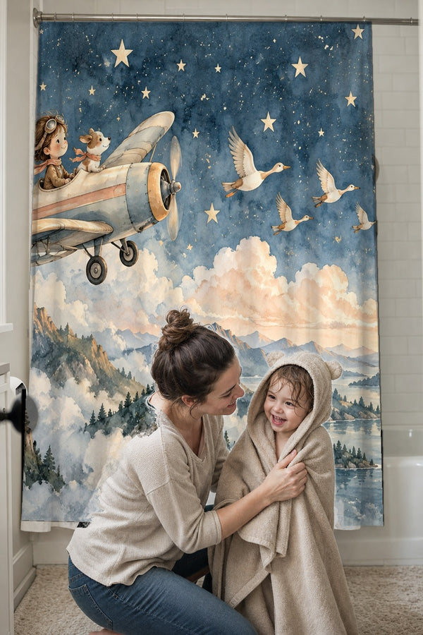 Mom drying her toddler in a hooded towel in front of the Moonlit Flight shower curtain