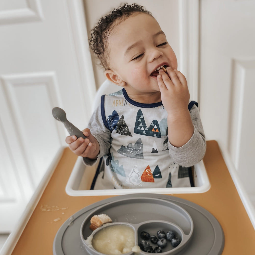 "Adventure Awaits Bapron for babies, featuring a fun design and practical, mess-free eating solution."