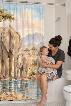 Mom holding her baby on the tub edge next to the Elephant Family Safari shower curtain