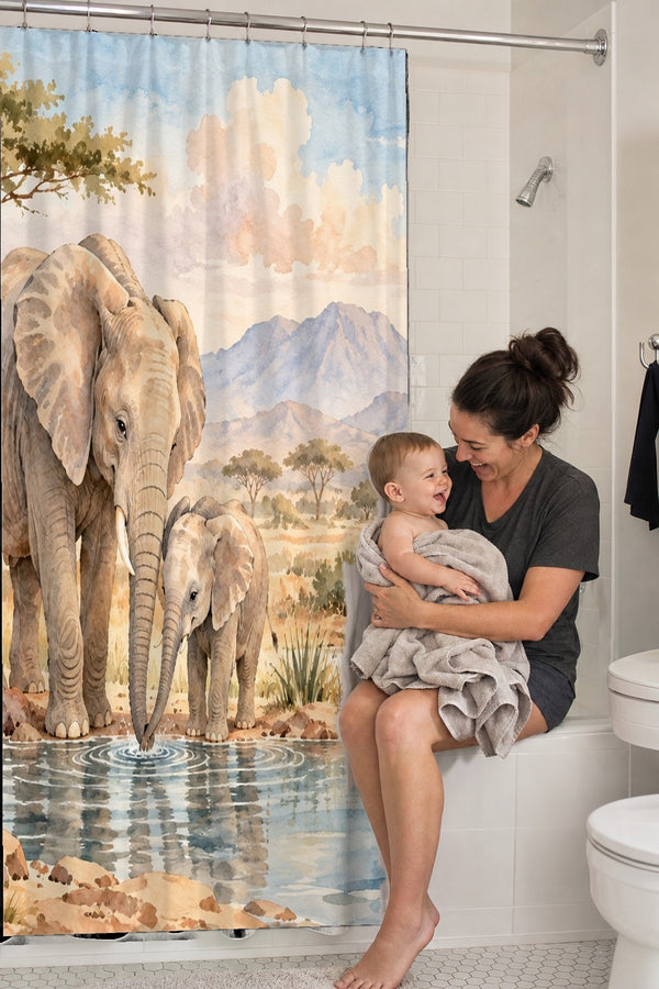 Mom holding her baby on the tub edge next to the Elephant Family Safari shower curtain