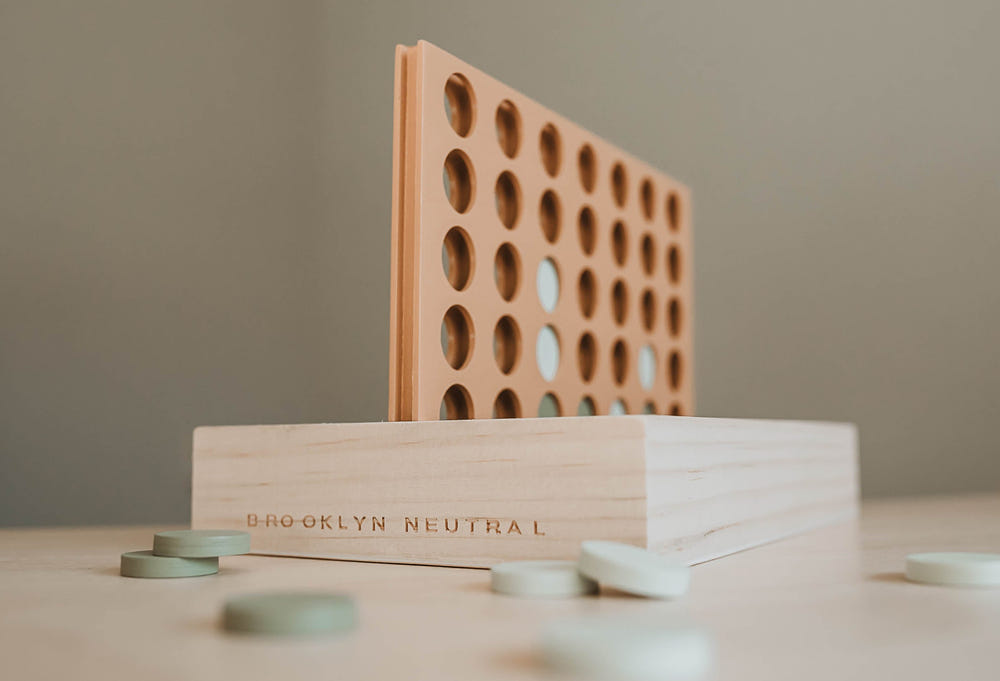 Wooden Four in a Row game for babies, promoting fun and learning in a stylish furniture design.
