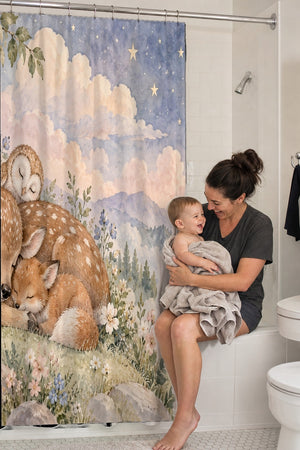 Mom holding her baby on the tub edge next to the Dreamland Friends shower curtain