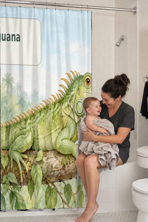 Mom holding her baby on the tub edge next to the I is for Iguana Alphabet shower curtain