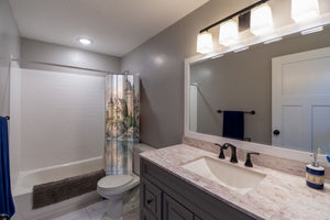Lakeside Castle Fairy Tale shower curtain pulled open in a gray kids bathroom
