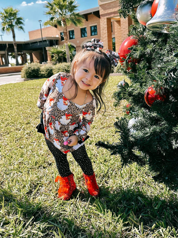 Leopard Santa ruffle romper for babies, festive holiday outfit, stylish and cute design, angle view.