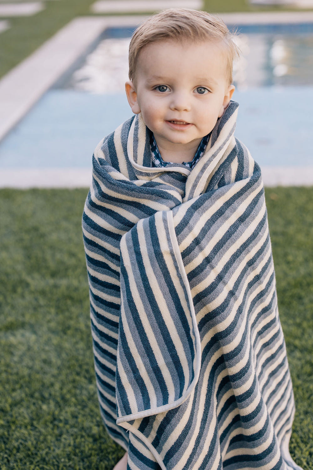 Blue stripe organic cotton beach towel for babies, perfect for sunny days at the beach or pool.