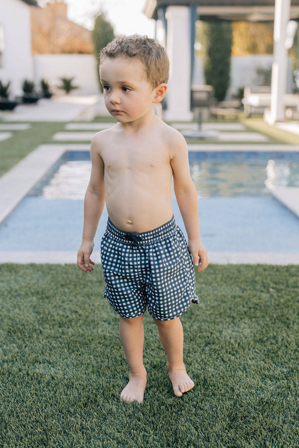 Navy gingham swim shorts for babies, stylish and comfortable beachwear for summer fun.