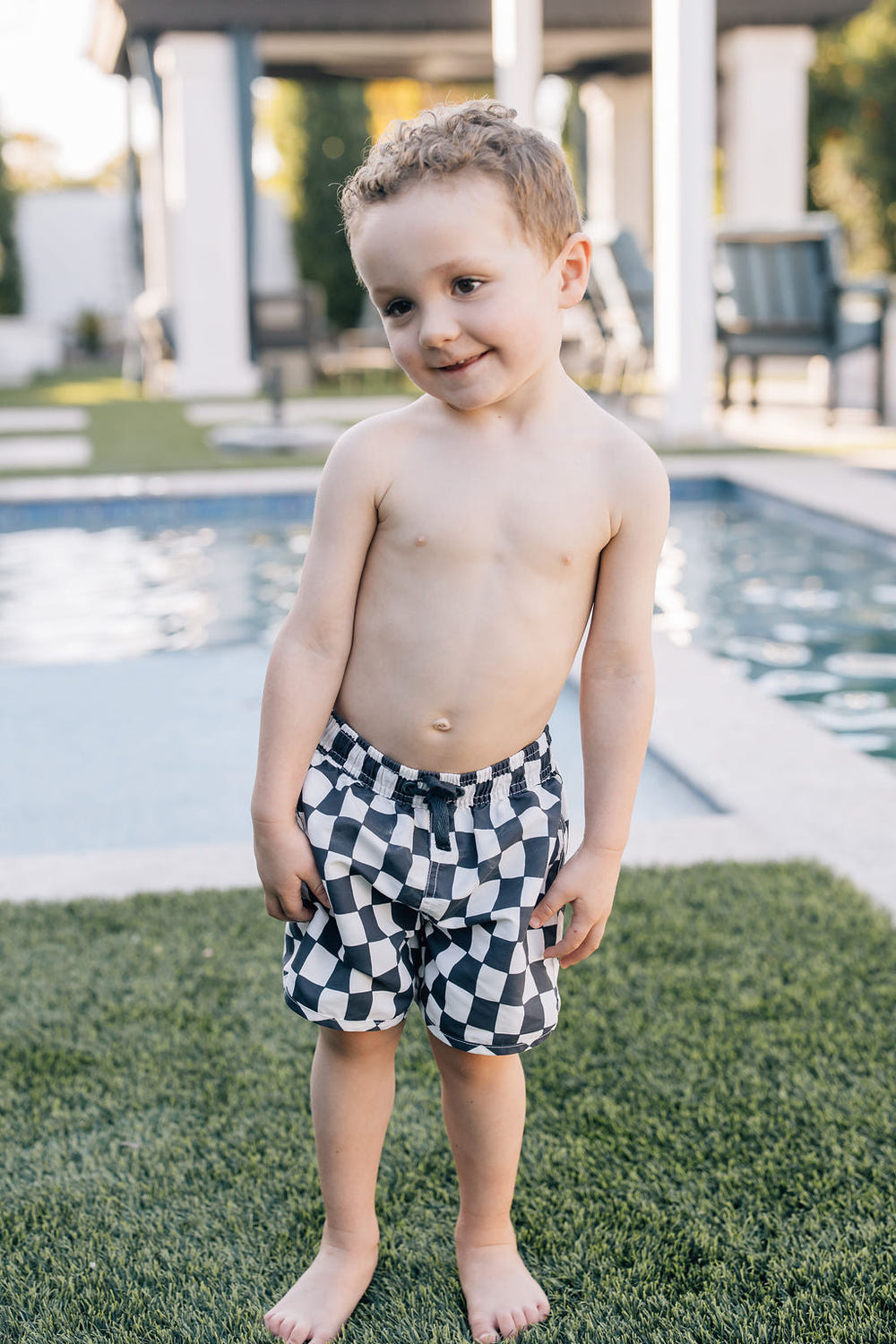 Wavy checkered swim shorts for babies, perfect for summer fun and beach days.