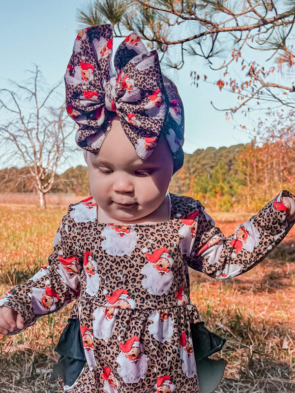 Leopard Santa ruffle romper for babies, festive holiday outfit, stylish and cute design, angle view.