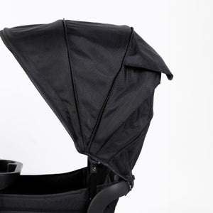 Oversized UV 50+ retractable canopy for baby strollers in Field Trip Black, shown from angle 2.